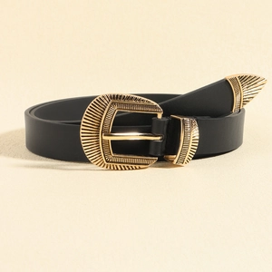 Detail of vintage gold-engraved buckle and metal tip on black leather belt for women