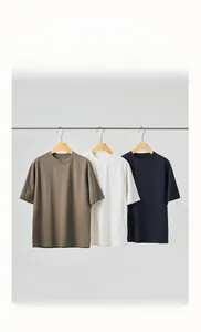 Three men's crew neck cotton t-shirts in brown, white and navy blue colors hanging