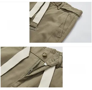 Detail van de olijfgroene broek met AAK rits, zijzakken en witte geweven riem