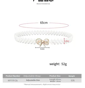 Detailed view of elastic pearl waist belt with gold bow buckle and rhinestone accents