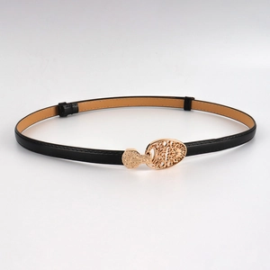 Gros plan détaillé d'une boucle vintage en métal doré sur une fine ceinture noire réglable