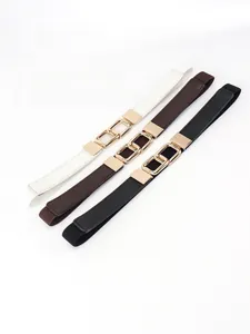 Close-up of three elastic belts in white, black and brown with gold interlocking buckles