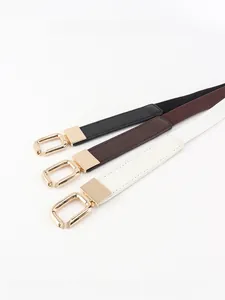 Close-up of three narrow elastic waist belts with shiny gold alloy square buckles