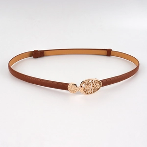 Détail de la boucle dorée sculptée sur la ceinture réglable en cuir marron pour femme