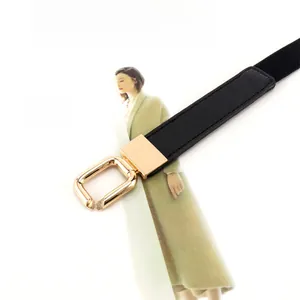 Close-up of golden alloy square buckle and black elastic belt on a fashion magazine