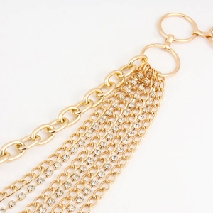 Close-up of gold layered body chain featuring metal links and sparkling rhinestones