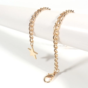 Detailed shot of golden star pendant and chain on a white display pedestal with lobster clasp