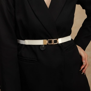 Detail of white litchi leather belt with interlocking gold buckle on black blazer