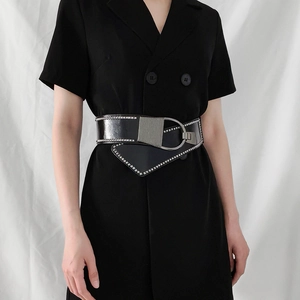 Détail de la ceinture large noire à rivets avec clous argentés et boucle en D en métal