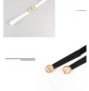 Detail von schmalen elastischen Taillengürteln mit goldener Rosenschnalle in Schwarz-Weiß