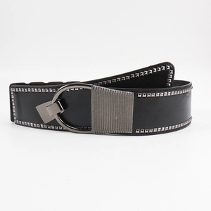 Détail d'une ceinture large noire avec rivets argentés et boucle ovale à rayures