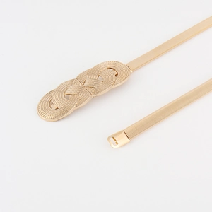 Close-up of golden elastic metal chain belt featuring a detailed triple ring knot buckle