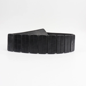 Détail de la ceinture large noire à rivets punk avec coutures verticales et élastique