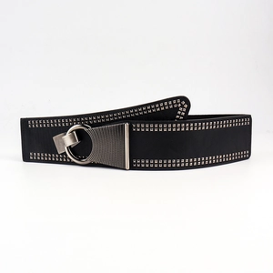 Détail de ceinture en cuir noir texturé avec boucles argentées et double rangée de rivets carrés