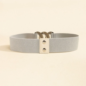 Close-up of elastic woven belt with cream leather patch and silver metal studs detail