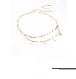 Close-up of golden layered waist chain with Eiffel Tower and alphabet pendants