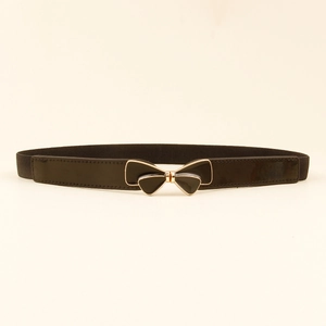 Detail of black elastic waist belt featuring a gold bow buckle and glossy finish texture