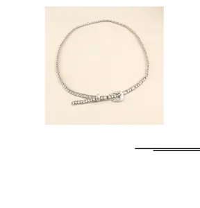 Detailed close-up of a silver waist chain featuring sparkling rhinestones and a buckle design