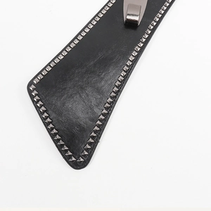 Détail de la ceinture punk noire en cuir mat avec des clous métalliques en pyramide