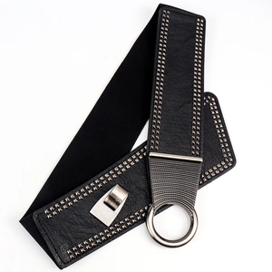 Détail d'une large ceinture élastique noire avec clous argentés et boucle en métal ronde