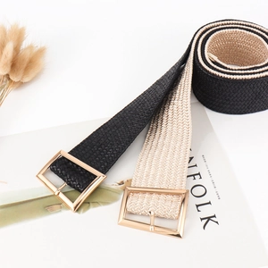 Detail of woven elastic waist belts in black and champagne gold with gold square buckles
