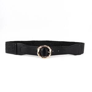 Macro detail of the golden bamboo texture buckle on black elastic waist belt