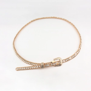 Detail of golden rhinestone waist chain with vintage western floral engraved buckle