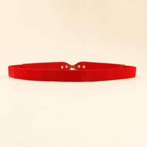 Detail of red elastic waist belt featuring a polished gold interlocking metal buckle