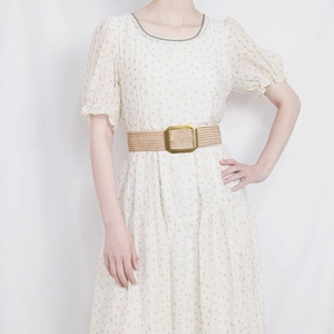 Detail of floral chiffon dress featuring an elastic woven waist belt with gold square buckle