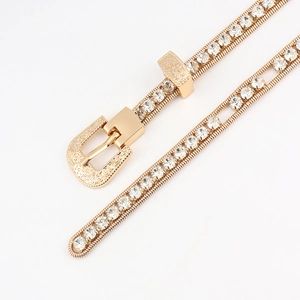 Macro detail of golden rhinestone waist chain featuring vintage engraved buckle and diamonds