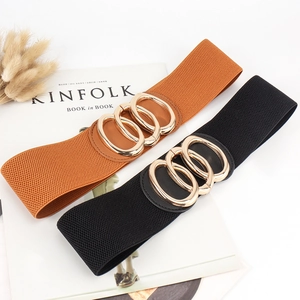Detail of wide elastic waist belts with interlocking triple ring gold buckles in black and brown