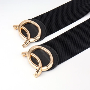Close-up of black elastic belt featuring modern gold buckle and woven texture detail