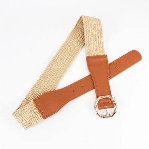 Detail of woven straw belt featuring a gold bamboo-style buckle and faux leather accents