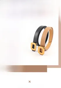 Detail of slim PU leather belts in black and tan with golden rectangular metal buckles