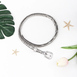 Detail of silver rhinestone waist chain with intricate floral engraving on the metal buckle