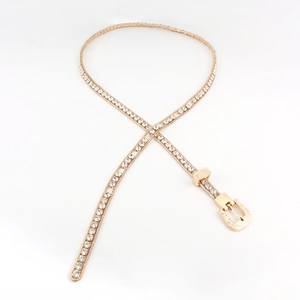 Detail of a thin gold rhinestone waist chain with vintage engraved buckle and sparkling stones