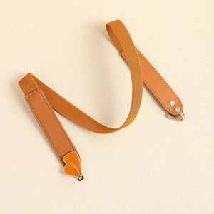 Close-up of brown elastic belt with golden heart-shaped buckle and leather texture