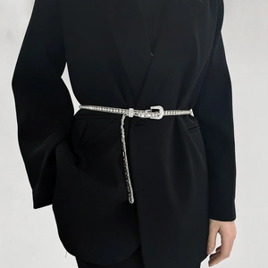 Close-up of sparkling rhinestone belt with silver metal buckle on a black suit blazer