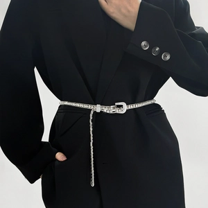 Detail of slim silver rhinestone waist chain belt with sparkling D-buckle on black suit