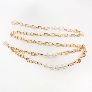 Détail de la chaîne de taille dorée à double couche avec perles blanches et pendentif pièce