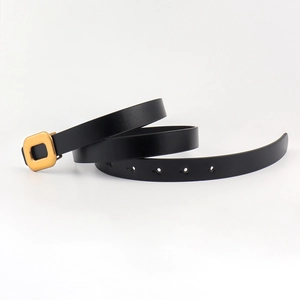 Close-up of black thin PU leather belt with a golden square buckle and adjustable holes