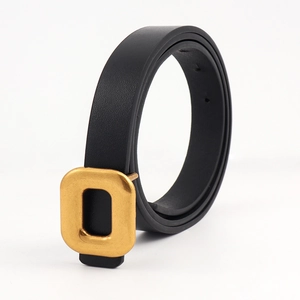 Detail of slim black PU leather belt featuring a polished gold rectangular metal buckle