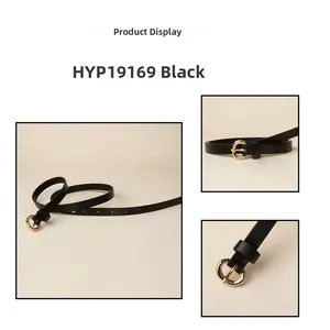 Close-up of minimalist black thin leather belt with a round golden metal buckle
