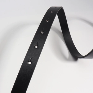Close-up detail of matte black PU leather belt with neatly punched holes and smooth edges