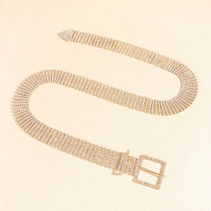 Détail d'une ceinture dorée ornée de strass avec boucle en cristal et maille souple
