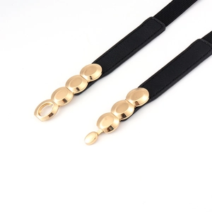 Détail de la ceinture élastique noire avec boucle métallique ovale dorée élégante