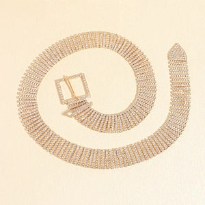 Détail d'une ceinture dorée flexible ornée de strass brillants avec maille chic