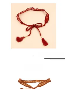 Detail shot of woven lace waist belt with tassel pendants in dark red and brown tones