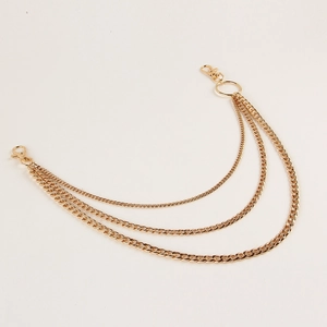 Close-up of triple-layered gold metal pant chains with secure lobster clasps