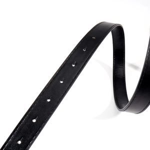 Détails de la ceinture en cuir noir grainé avec coutures et perforations précises